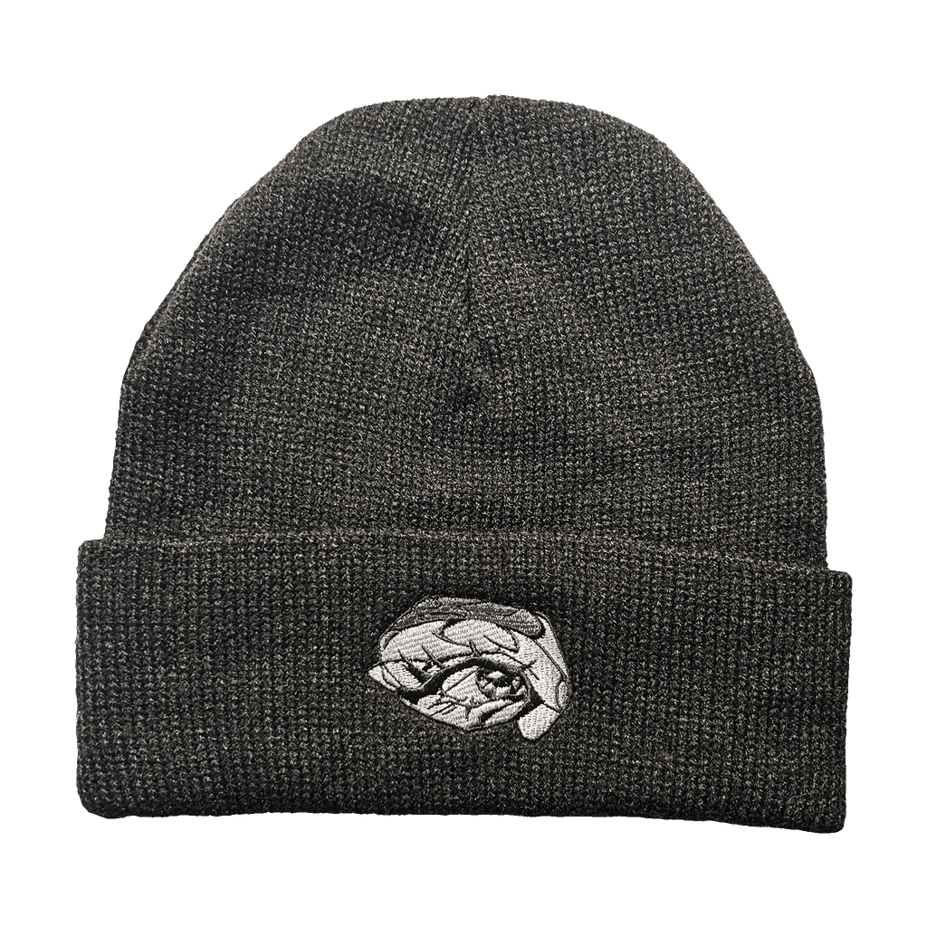 Dark black knit toque with a detailed grayscale embroidered eye patch on the cuff